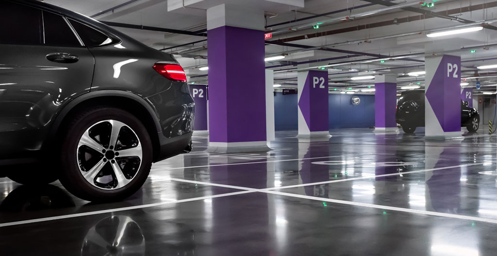 Une main tient des clés de voiture avec un ticket de parking sur une surface moderne avec arrière-plan flouté